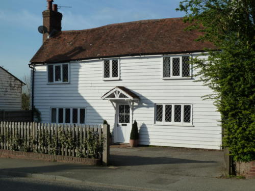 A white weatherboarded house in the village